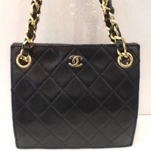 Load image into Gallery viewer, This Chanel Vintage Black Lambskin Limited Edition Mini has the diamond stitched pattern, gold hardware and double chain handles. The chain handles have a strip of leather woven between its links and are shoulder bag length. The CC logo is in gold on the center front top of the bag. This bag has a burgandy interior.