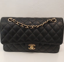 Load image into Gallery viewer, This Chanel Vintage Caviar Double Flap 255 is black with gold hardware and has the diamond stitch pattern. It has the double CC logo in gold on a lip coming from flap. It has a gold shoulder chain with a strip of black leather woven between the links of the chain. The interior of this bag is red.