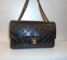 Load image into Gallery viewer, This Chanel Double Flap Lambskin has 24 karat gold hardware. The front flap has the double C latch in gold and the double shoulder strap has a thin black leather strip woven between the gold links. The interior of this bag is a lovely shade of red.