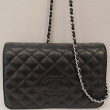 Load image into Gallery viewer, This Chanel Vintage Full Flap WOC Black Lambskin bag is in the diamond stitch design with the CC logo embroidered in a larger diamond section on the front flap of the bag. It has silver hardware and a thin strip of black leather woven between the links of the shoulder chain. The inside of the bag, also black leather, has a zippered section along with pockets for cards.