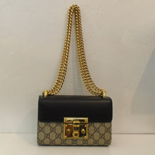 Load image into Gallery viewer, This Gucci Vintage Supreme GG Padlock Shoulder Bag has the Gucci design in the body of the bag. It has a black front flap, brown sides and back pocket and gold hardware. This bag has a double shoulder chain and the interior is a soft camel.