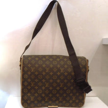 Load image into Gallery viewer, This Louis Vuitton Abbesses Monogram Messenger has a dark brown canvas adjustable shoulder strap. It has a pocket under the front flap, and a pocket on the back. Also on the back is a handle attached to the lip of the pocket. The front flap comes down to the bottom with a clasp at the end that hooks underneath the bag. The interior is camel color and has a zippered pocket.