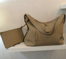 Load image into Gallery viewer, This Louis Vuitton Vintage Beige Empreinte Leather Carryall With Pochette is in the large monogram pattern and has gold hardware. The shoulder strap is adjustable and it also has an attached key holder. The interior is in the same beige color and does have an ink and water spot.