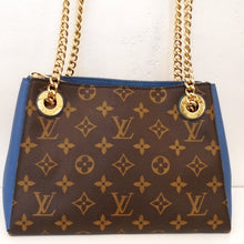 Load image into Gallery viewer, This Louis Vuitton Vintage Monogram Blue Jean Blue Sure'ne BB has the original monogram pattern on the back and front of the bag. The sides and interior of the bag are blue jean blue. It has a double chain shoulder chain with a shoulder guard on each chain. The interior of this bag has a middle zippered pocket with a pocket on each side.