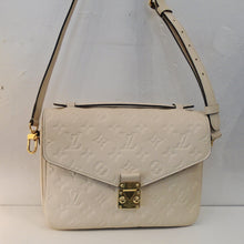 Load image into Gallery viewer, This Louis Vuitton Vintage Cream Empreinte Leather M`etis MM has an adjustable shoulder strap and a carrying strap. It has gold hardware and a zippered pocket on the back of the bag. The interior of this bag is dark camel.