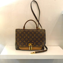 Load image into Gallery viewer, This Louis Vuitton Vintage Monogram Marignan With Strap is in the original monogram style except for directly underneath the front flap. There is a solid camel colored section just under and below the front flap which is actually a large pocket. The front flap, which gives you the illusion of a locked clasp, snaps onto the solid section. The bag has a carrying handle and a detachable shoulder strap. The interior of the bag is a soft camel color.