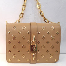 Load image into Gallery viewer, This Louis Vuitton Vintage Metal Rendez/Vous is a tan color with the monogram pattern in gold raised on the bag. It has a heavy gold shoulder chain and a gold lock clasp. The interior of this bag is in the original monogram pattern and colors.