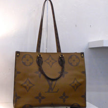 Load image into Gallery viewer, This Louis Vuitton Vintage Reverse On The Go GM has four separate sides that rotate the light background with dark monogram to dark monogram with light background. It has double carrying handles and double shoulder straps. The interior is red.