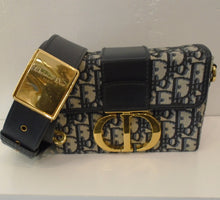 Load image into Gallery viewer, This Dior Navy Oblique Jacquard Montaigne Box 30 has navy trim and gold hardware. The Dior print is navy &amp; gray. The interior of this bag is navy &amp; black and it has a removable navy shoulder strap with a gold buckle.
