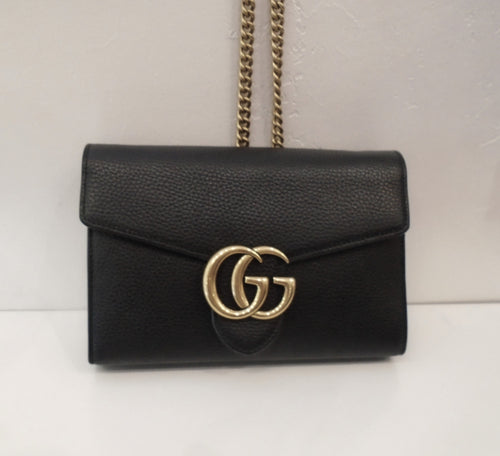 This Gucci Vintage Black Shoulder Bag has gold trim and a shoulder chain. The chain is removable.  The inside of this bag is accordion style with a zippered compartment and ample card pockets. This bag has the GG logo in gold on the front of the bag.