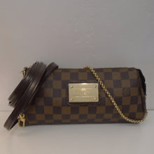 Load image into Gallery viewer, This Louis Vuitton Vintage Damier Ebene Eva Pochette has gold hardware and has a gold plaque on the front of the bag. It has a detachable leather strap. The interior of this bag is red.
