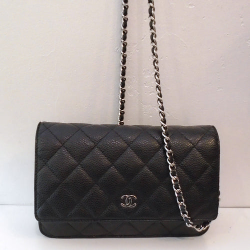 This Chanel Vintage Black Caviar Leather WOC Silver Hardware is in the diamond stitched pattern. It has the CC logo on the front flap of the bag in the silver hardware and the shoulder chain has a black strip of leather woven between the links of the chain. It has a pocket on the back of the bag. The interior is burgandy with two zippered pouches along with card pouches.