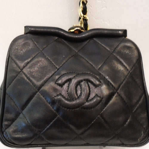 This Chanel Vintage Black Limited Edition Quilted Conversion Bag is a small bag with a long gold chain with a leather strip woven between the links. It has a leather tassle on the shoulder chain. The shoulder chain is removable making this small bag into a handsome clutch. It has the diamond stitch pattern with the CC logo stitched in the center of the bag. The interior of the bag, which is the same color as the outside, has a zippered pocket.
