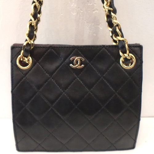 This Chanel Vintage Black Lambskin Limited Edition Mini has the diamond stitched pattern, gold hardware and double chain handles. The chain handles have a strip of leather woven between its links and are shoulder bag length. The CC logo is in gold on the center front top of the bag. This bag has a burgandy interior.