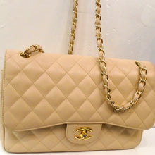 Load image into Gallery viewer, This Chanel Vintage Cream Caviar Double Flap 30 has the diamond stitched pattern and gold hardware. The shoulder chain has a thin strip of leather woven between the links of the chain. There is a pocket on the outside back of this bag. The interior of the bag is a soft cream color.
