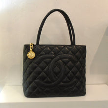Load image into Gallery viewer, This Chanel Caviar Leather Top Handle Medallion Bag has the diamond stitched pattern with large CC logo stitched into front of bag. It has a gold medallion, also with the Chanel logo, attached to the top zipper. It has double shoulder/carrying straps. The interior of this bag is also black.
