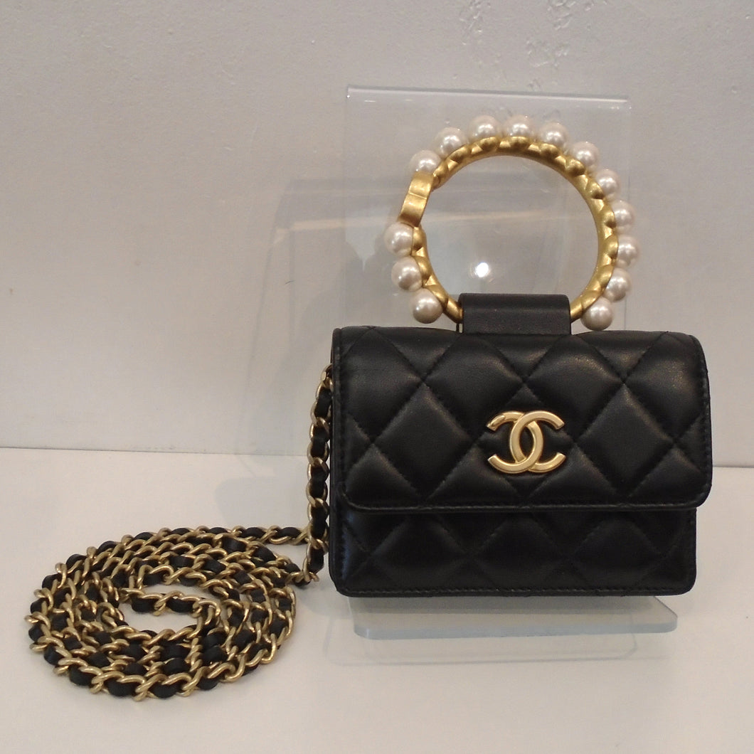 This Chanel Vintage Faux Pearl Clutch With Chain has the stitched diamond pattern and gold toned hardware which includes the Chanel Logo on the front center of the bag, the shoulder chain and the carrying handle. The shoulder chain also has a thin strip of leather woven between the chain links. The carrying handle has faux pearls sitting on the carrying handle.