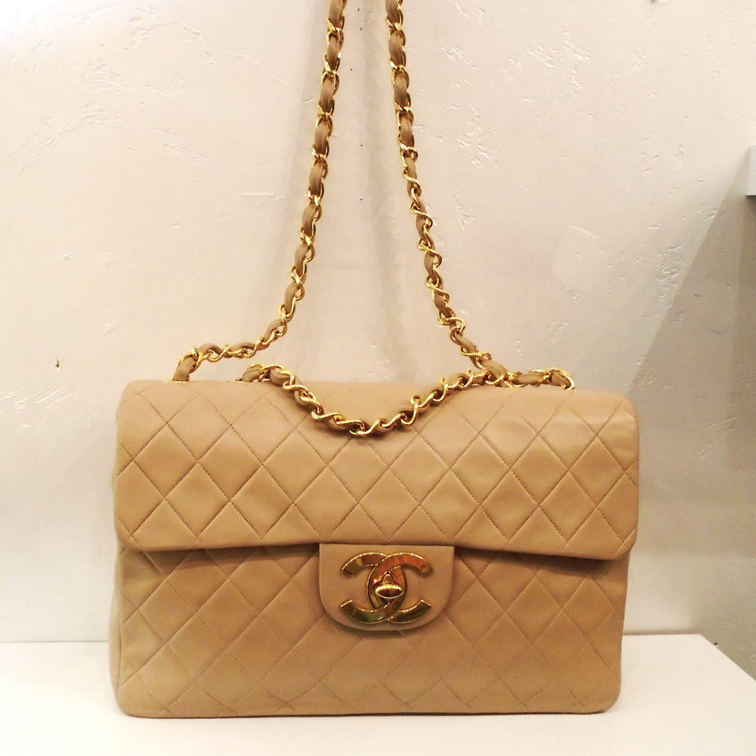 This Chanel Vintage Flesh Tone Maxi 34 Shoulder Bag has  24 Karat Gold Plated Hardware and is in the diamond stitched design. It has a long shoulder chain with a thin strip of  leather woven between the links.  The clasp is on a lip on the flap with the CC logo as the latch. The interior of the bag is in the same flesh tone shade.