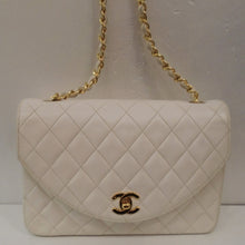 Load image into Gallery viewer, This Chanel Lambskin Pearl White Flap has the diamond stitched design and 24 Karat Gold plated hardware. It has a chain shoulder strap with a thin white leather strip woven between the chain links. The clasp is the CC logo in gold.
