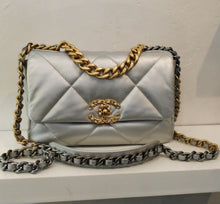 Load image into Gallery viewer, This Chanel Vintage Silver 19 is silver with diamond stitching. It has the Chanel logo in gold with silver beads. The shoulder chain is gold and silver with a silver shoulder guard. The interior of this bag is silver.
