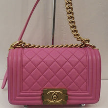 Load image into Gallery viewer, This Chanel Vintage Small Hot Pink Boy Bag has gold hardware which includes the front latch and part of the shoulder strap. The shoulder strap is a combination of pink leather and a thick gold chain which is 24 carat gold plated. There are light color transfers on the corner and back of this bag. The interior of this bag is also pink.

