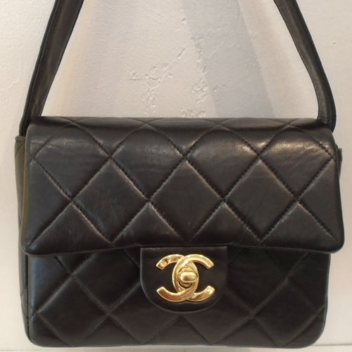 This Chanel Vintage Very Dark Chocolate Shoulder Bag has 24 Karat Gold Plating with dark chocolate and red interior and a zippered pocket. It also has an outside back pocket.
