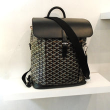 Load image into Gallery viewer, This Goyard Brown/Black Alpin Back Pack MM has the Goyard pattern in brown and black. The top flap is black with a buckle strap. It has shoulder straps and a top handle for hanging it up. This bag has a white interior.
