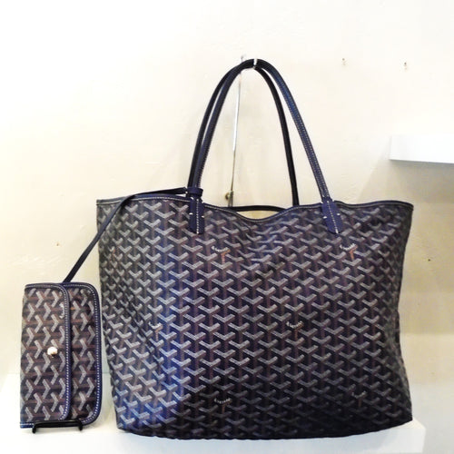 This Goyard Navy Saint Louis Gm is a tote size bag in the original Goyard pattern. Also included with this bag is a snap wallet that is attached to the inside of the bag for convenience. The interior of the bag is a soft cream color.