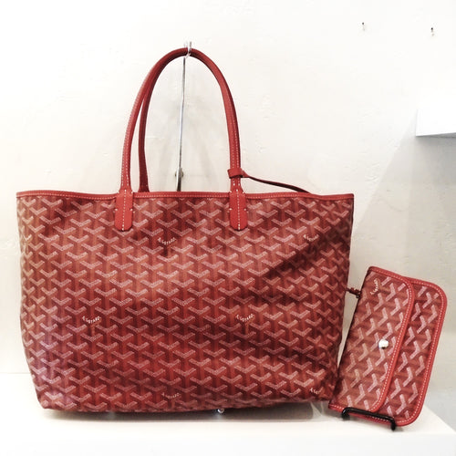This Goyard Red Saint Louis MM has the original Goyard design. A snap wallet is included attached to the bag. The interior of this bag is a soft cream color.