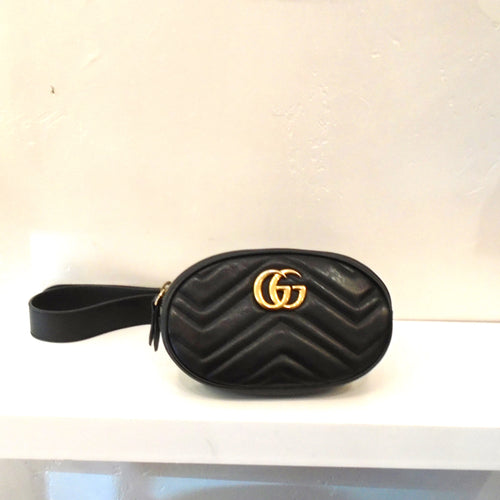 This Gucci Vintage Belt Bag is black and has the Chevron design on the bag. It has a zippered opening, the Gucci logo in gold and an adjustable black belt.