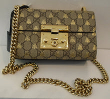 Load image into Gallery viewer, This Gucci Vintage Bee Small Padlock Bag is in the original Gucci design with golden bees. It has a gold shoulder chain. The sides are black and it has a black card holder on the back. The interior of this bag is a soft peach.
