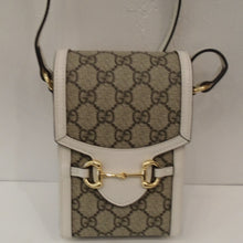 Load image into Gallery viewer, This Gucci Vintage Cream/Snaffle Crossbody is in the Gucci pattern in cream trim with a tongue on the front flap. It has a gold hardware snaffle across the tongue to hold the crossbody closed. It has a cream leather adjustable shoulder strap. The interior of this bag is a light brown.
