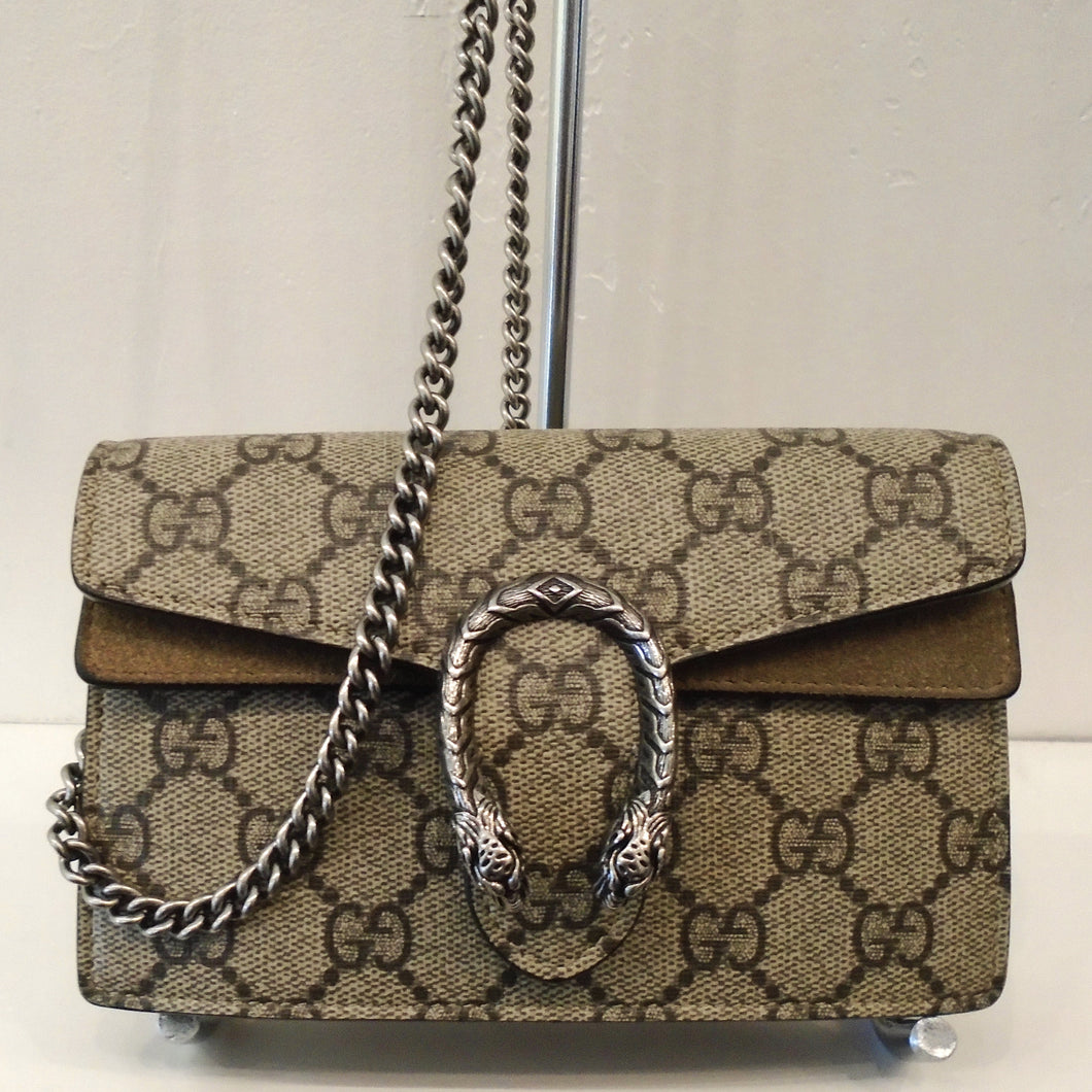 This Gucci Vintage Mini Dionysus Supreme GG has the original Gucci Pattern with silver hardware. The front clasp is in the form of a two headed snake in the shape of a horseshoe. The bag has a long crossbody length shoulder chain and the interior is a soft beige.