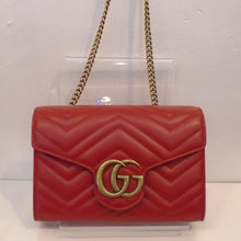 Load image into Gallery viewer, This Gucci Marmont WOC is red with gold hardware which includes the front Gucci Logo and the shoulder chain. The interior of this bag is black with a middle zippered compartment.

