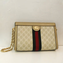 Load image into Gallery viewer, This Gucci Vintage Ophidia Beige &amp; Cream Shoulder Bag has beige background with cream Gucci design. It also has the Gucci logo in gold on an upper lip of the bag. Coming from the lip is a black and red strap wrapping to the back of the bag. This bag has a gold shoulder chain and camel interior
