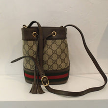 Load image into Gallery viewer, This Gucci Vintage Supreme GG Ophidia Mini Bucket bag has the Gucci pattern, dark brown trim with red and green stripes on the bottom of the bag and a long shoulder strap. The interior of this bag is dark cream.
