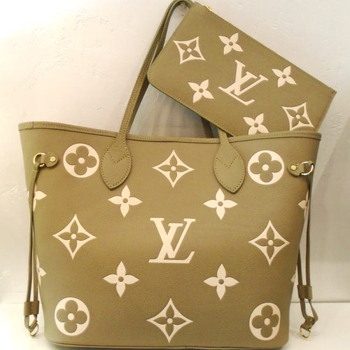 This Louis Vuitton Vintage Bicolor Neverfull with Pouch appears to be in Khaki with cream colored large monogram print. The bag has side ties and long carrying handles. This bag comes with an identical zippered pouch. The interior of this bag is a soft Khaki.