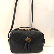 Load image into Gallery viewer, This Louis Vuitton Vintage Black Empreinte Leather Saintonge has the large Louis Vuitton Monogram imprinted in the leather. It has gold hardware, a double headed zipper on the top of the bag along with a carrying handle mesh with the bag. It also has a shoulder strap. The front of the bag has a gold hardware diamond shape with two leather tassels at its center. The interior of the bag is black.
