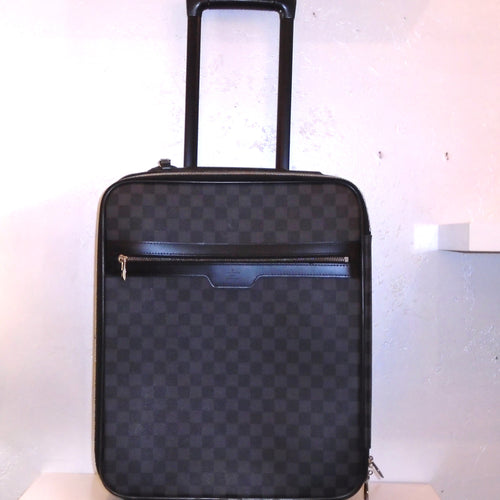 This Louis Vuitton Black Graphite Travel Luggage #45 has a top pull out handle and bottom wheels. It has a zippered pouch in the front and multiple zippered sections inside the case.