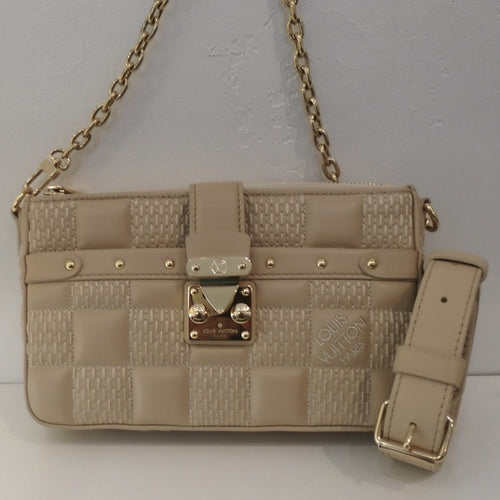 This Louis Vuitton Vintage Beige Quilted Troca Damier is in a checkerboard pattern with a solid and damier stitched pattern. It has gold hardware and detachable shoulder straps. The interior of this bag is also beige