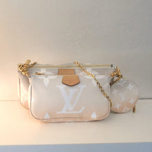 Load image into Gallery viewer, This Louis Vuitton Vintage By The Pool Pochette Accessoire is light pink with white large monogram. It has an accompanying round change purse in the same colors, however the monogram is small. This bag has gold hardware and is trimmed in camel leather.  It is made of two pouches the smaller one is in the front. The interior is a dark cream with white stripes.
