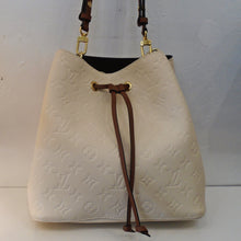 Load image into Gallery viewer, This Louis Vuitton Cream Empreinte Leather Neo Noe has a brown leather drawstring and gold hardware. The interior is blue with a zippered pocket in the center. Two detachable straps are included with this bag.
