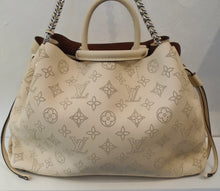 Load image into Gallery viewer, This Louis Vuitton Vintage Cream Mahina leather Bella Tote has the Louis Vuitton Monogram Pattern printed on the bag, side straps, silver chain and leather shoulder strap along with double carrying handles. The interior of this bag is a rust brown.
