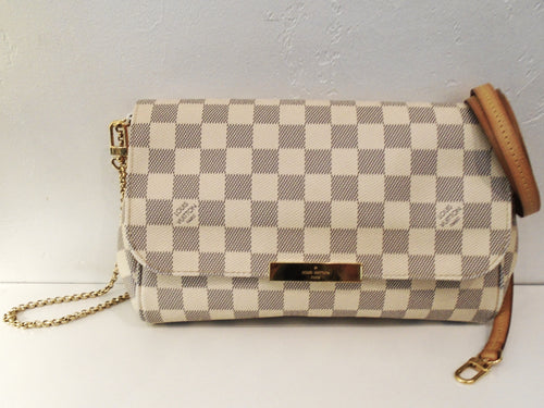 This Louis Vuitton Damier Azur Favorite MM has camel trim and gold hardware which includes the Louis Vuitton name plate on the lip of the front flap. The interior of the bag is a light camel.