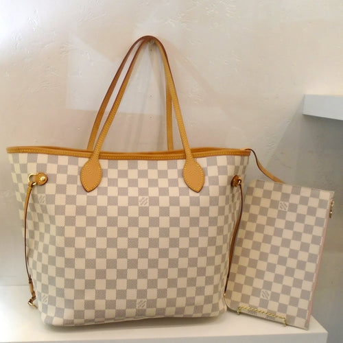 This Louis Vuitton Vintage Damier Azur Neverfull MM with Pouch has camel trim, side ties and gold hardware. The pouch is in matching Damier Azur and is zippered. The interior of the bag is in Ballerina.