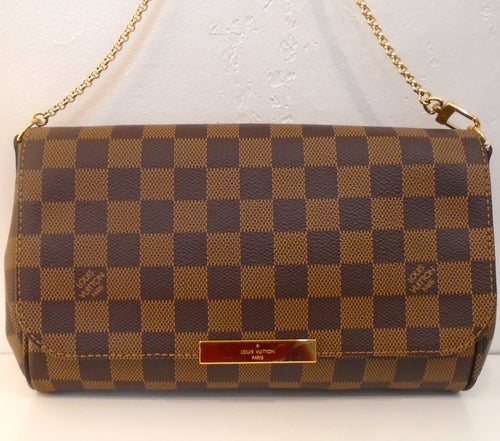 This Louis Vuitton Damier Ebene Favorite MM has gold hardware which includes a thin shoulder chain and Louis Vuitton name plate on the clasp. The interior of this bag is red.