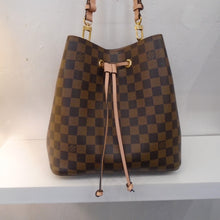 Load image into Gallery viewer, This Louis Vuitton Vintage Damier Ebene Neo Noe is in the brown Damier Ebene pattern with a pink draw string and a pink shoulder strap. It has gold hardware which includes the zippered inside center pouch. The interior of this bag is pastel pink.
