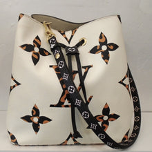 Load image into Gallery viewer, This Louis Vuitton Vintage Empreinte Leather Giant Jungle N`eo N`oe has a white front with extra large monogram which is black with tiger stripes. The back of the bag is black, orange and white stripped which meets the front halfway to the sides. The shoulder strap is black with white monogram and the interior of the bag is cream color.
