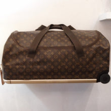 Load image into Gallery viewer, This Louis Vuitton Vintage Horizontal Soft Duffel #60 is in the brown monogram pattern. It has double handles on the side of the bag, a single handle on the top of the bag and two wheels on the bottom. It has a frame around the back of the suitcase for reinforcement. It also has a digital lock.
