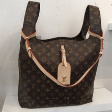 Load image into Gallery viewer, This Louis Vuitton Vintage Monogram Atlantis GM is in the original monogram and has wide shoulder handles on both sides at top of the bag. The shoulder handles are made from the same material at the rest of the bag. It has a key holder and additional strap in a cream tan color. The interior of the bag is camel and is open with no pockets.
